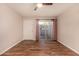 Cozy living room with wood-look flooring, ceiling fan, white door, and a sliding glass door at 1331 W Baseline Rd # 167, Mesa, AZ 85202
