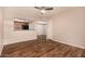 Open-concept living room with wood-look floors, a ceiling fan, and a view into the kitchen area at 1331 W Baseline Rd # 167, Mesa, AZ 85202
