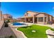 Backyard featuring a pool, turfed lawn, and manicured landscaping at 15229 S 18Th Dr, Phoenix, AZ 85045