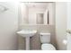 Powder room featuring a pedestal sink, a white toilet, and a large mirror at 15229 S 18Th Dr, Phoenix, AZ 85045
