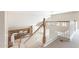 Upstairs hallway features staircase with wood railing overlooking kitchen and living area at 15229 S 18Th Dr, Phoenix, AZ 85045