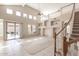 Spacious living room featuring tile floors, high ceilings, and a staircase leading to the second floor at 15229 S 18Th Dr, Phoenix, AZ 85045