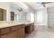 Main bathroom featuring double sinks, a soaking tub, and a glass enclosed shower at 15229 S 18Th Dr, Phoenix, AZ 85045