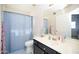 Bright bathroom with a dark vanity, patterned floor, and blue shower curtain at 1750 E Erie St, Gilbert, AZ 85295