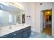 Bathroom featuring a dual sink vanity, a large mirror, and a doorway to the walk in closet at 1750 E Erie St, Gilbert, AZ 85295
