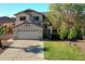 Welcoming two-story home with a two-car garage, lush green lawn, and a meticulously maintained landscape at 1750 E Erie St, Gilbert, AZ 85295