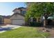 Inviting two-story home with a well-manicured front lawn, mature shade tree, and a two-car garage at 1750 E Erie St, Gilbert, AZ 85295