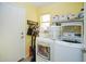 Well-organized laundry room with front-loading washer and dryer, overhead shelving, and a door to the exterior at 1750 E Erie St, Gilbert, AZ 85295