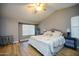 Bright main bedroom with a large window, a ceiling fan, and a bed with decorative throw pillows at 1750 E Erie St, Gilbert, AZ 85295