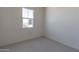 This is a bedroom with gray carpeting and a window that allows natural light to come in at 18047 W Long Lake Rd, Goodyear, AZ 85338