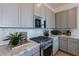Well-equipped kitchen with stainless steel range, microwave, marble countertops, and modern cabinets at 18047 W Long Lake Rd, Goodyear, AZ 85338