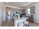 Kitchen island with marble countertop, bar stools, and view into the modern kitchen at 18047 W Long Lake Rd, Goodyear, AZ 85338
