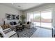 Bright living room with modern decor, neutral tones, and large windows with a view of the outdoor patio at 18047 W Long Lake Rd, Goodyear, AZ 85338