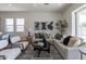 Bright living room with modern decor, neutral tones, and large windows showcasing lots of natural light at 18047 W Long Lake Rd, Goodyear, AZ 85338
