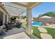Inviting backyard with patio seating, lush green turf, and a sparkling blue swimming pool at 18203 W Port Royale Ln, Surprise, AZ 85388