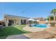 Lush backyard featuring a sparkling pool, patio seating, and built-in grill area at 18203 W Port Royale Ln, Surprise, AZ 85388