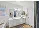 Well-lit bathroom features double sinks, large mirror, with tile floors at 18203 W Port Royale Ln, Surprise, AZ 85388