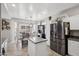 Open kitchen features a center island, stainless steel refrigerator, tile flooring, and a breakfast nook dining space at 18203 W Port Royale Ln, Surprise, AZ 85388