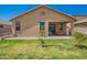 Backyard with a small grass area, paved patio, and the rear exterior of the house at 18241 W Foothill Dr, Surprise, AZ 85387