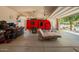 Large garage with a red trailer, storage containers, and a daybed for relaxing at 18241 W Foothill Dr, Surprise, AZ 85387
