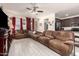 Spacious living room featuring tile floors, ceiling fan, and comfortable reclining sofa at 18241 W Foothill Dr, Surprise, AZ 85387