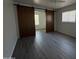 Bedroom featuring sleek laminate flooring, a window, and closet with a barn door at 2045 E Orange St, Tempe, AZ 85281