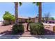 Exterior of a house featuring desert landscaping with mature palm trees and bushes at 20769 N 106Th Ln, Peoria, AZ 85382