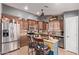 Well-equipped kitchen with wooden cabinets, modern stainless steel appliances, and a central island at 20769 N 106Th Ln, Peoria, AZ 85382