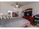 Bedroom featuring a ceiling fan, a dresser, a mirror, and a door to the walk-in closet at 20769 N 106Th Ln, Peoria, AZ 85382