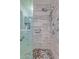 Modern shower featuring pebble flooring, tiled walls, grab bars, rainfall shower head and glass door at 20769 N 106Th Ln, Peoria, AZ 85382
