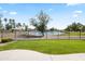 Scenic backyard view showcasing a well-kept lawn, a black metal fence, and a serene pond at 21480 N 56Th Ave, Glendale, AZ 85308