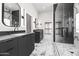 Modern bathroom with marble floors, sleek vanity, and glass-enclosed shower at 21480 N 56Th Ave, Glendale, AZ 85308