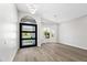 Modern entryway with wood floors, statement lighting, and view of the front yard through windows at 21480 N 56Th Ave, Glendale, AZ 85308