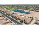 Aerial view of a community featuring tile roofs, desert landscaping, a lake, and a nearby golf course at 2163 N 164Th Dr, Goodyear, AZ 85395