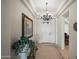 Elegant foyer featuring a decorative chandelier, tile flooring, and an ornate console table at 2163 N 164Th Dr, Goodyear, AZ 85395