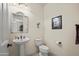 Cozy half-bathroom featuring a pedestal sink, modern fixtures, and neutral wall decor at 2163 N 164Th Dr, Goodyear, AZ 85395