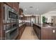 Bright kitchen showcasing stainless steel appliances, granite countertops, and rich dark wood cabinetry at 2163 N 164Th Dr, Goodyear, AZ 85395