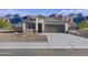 Charming single-story home with a neutral color palette, complemented by a well-maintained front yard and desert landscaping at 22650 N Lynn St, Maricopa, AZ 85138