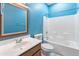 Bright blue full bathroom featuring a shower-tub combo and a wood-framed mirror at 2541 N 86Th Ave, Phoenix, AZ 85037