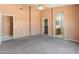 Large bedroom with neutral carpeting, an arched doorway to the ensuite, and a ceiling fan at 2541 N 86Th Ave, Phoenix, AZ 85037