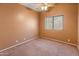 Carpeted empty bedroom featuring a ceiling fan and a window providing natural light at 2541 N 86Th Ave, Phoenix, AZ 85037