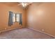 Empty carpeted bedroom with single window, neutral paint, and ample natural light at 2541 N 86Th Ave, Phoenix, AZ 85037