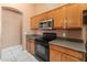 Well-lit kitchen showcasing stainless steel microwave, electric range, and plenty of storage at 2541 N 86Th Ave, Phoenix, AZ 85037