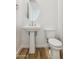 Clean bathroom featuring a pedestal sink, modern faucet, and wood-look flooring at 27358 N 69Th Dr, Peoria, AZ 85383