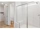 Modern bathroom featuring a glass enclosed shower with white marble tile and wood-look flooring at 27358 N 69Th Dr, Peoria, AZ 85383