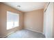 Bright bedroom with neutral carpet, a large window, and closet at 310 E Payton St, San Tan Valley, AZ 85140
