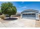 Single-story home featuring a well-maintained lawn and attached two-car garage with grey paint at 310 E Payton St, San Tan Valley, AZ 85140