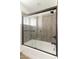 Bathroom with glass-enclosed shower featuring sleek, vertically-tiled walls and dark hardware at 3102 E Mariposa St, Phoenix, AZ 85016