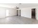 Spacious bedroom featuring gray wood-look floors, ceiling fan, and three doors leading to bathroom and backyard at 3102 E Mariposa St, Phoenix, AZ 85016