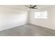 An empty room with a ceiling fan and light gray wood-look flooring, freshly painted in white at 3102 E Mariposa St, Phoenix, AZ 85016